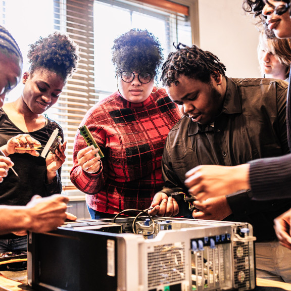 A group of people working together to fix a computer 