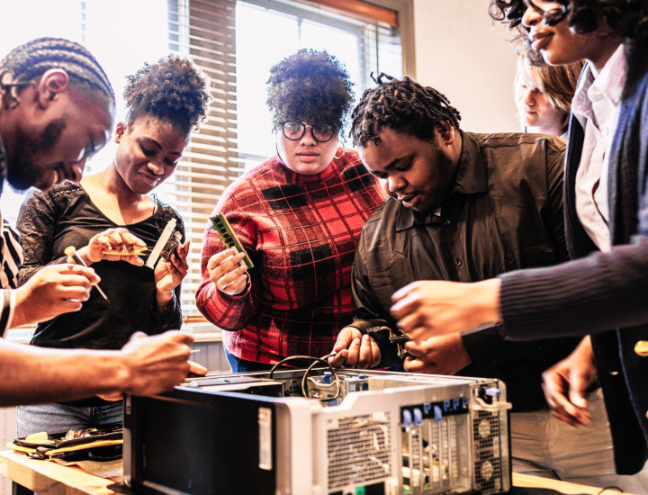 A group of people working together to fix a computer 